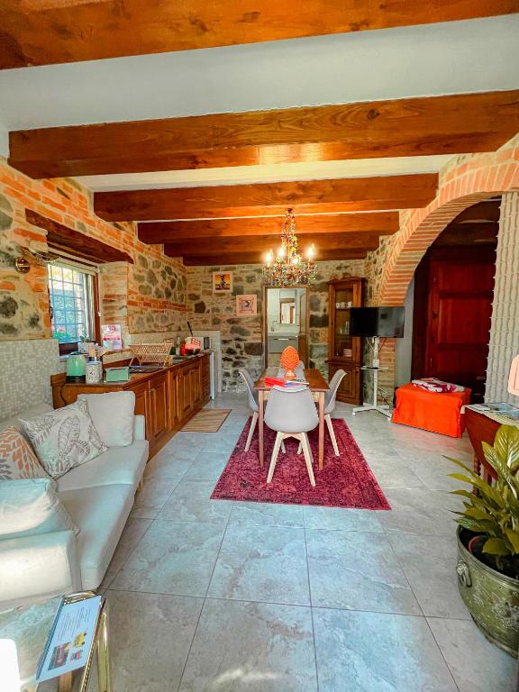 Soggiorno con divano, cucina e muri in pietra antica